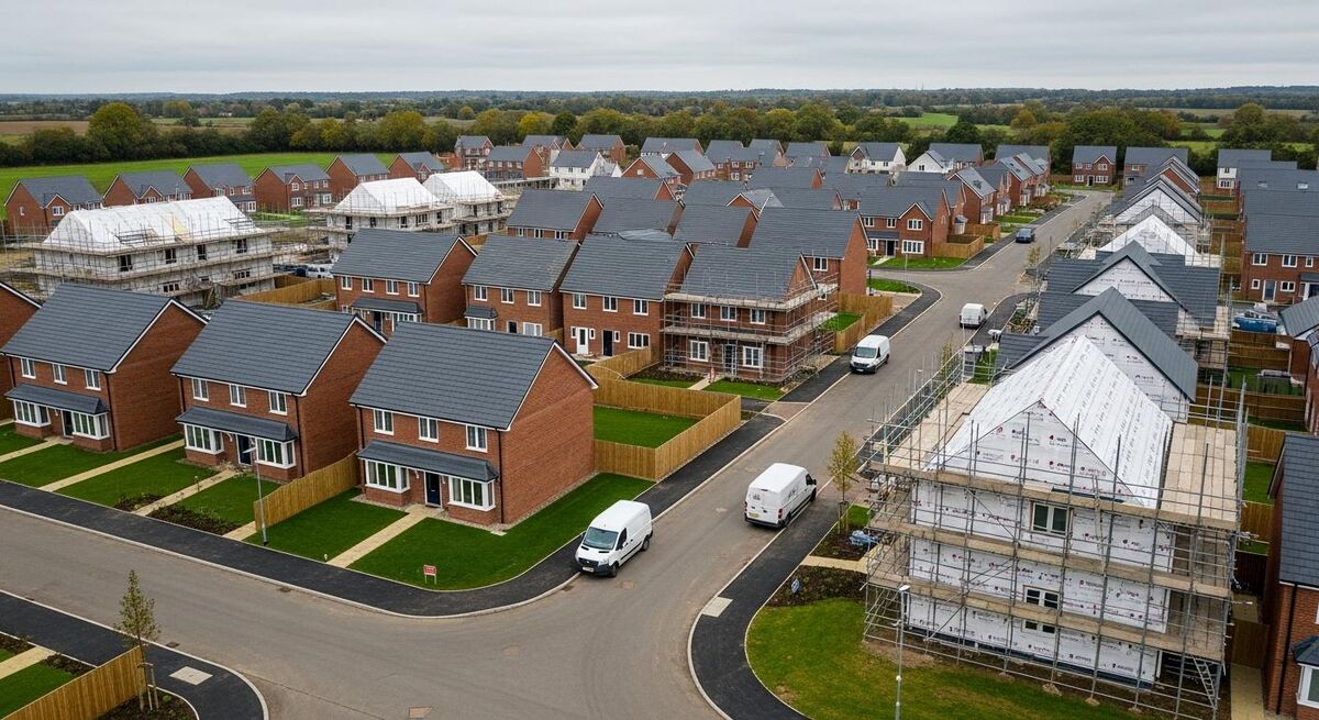 Aerial view of a partially built UK housing estate with neat rows of homes under construction