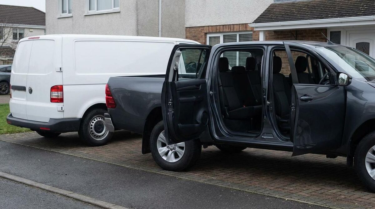 A double cab pickup with a second row of seats parked next to a standard panel van