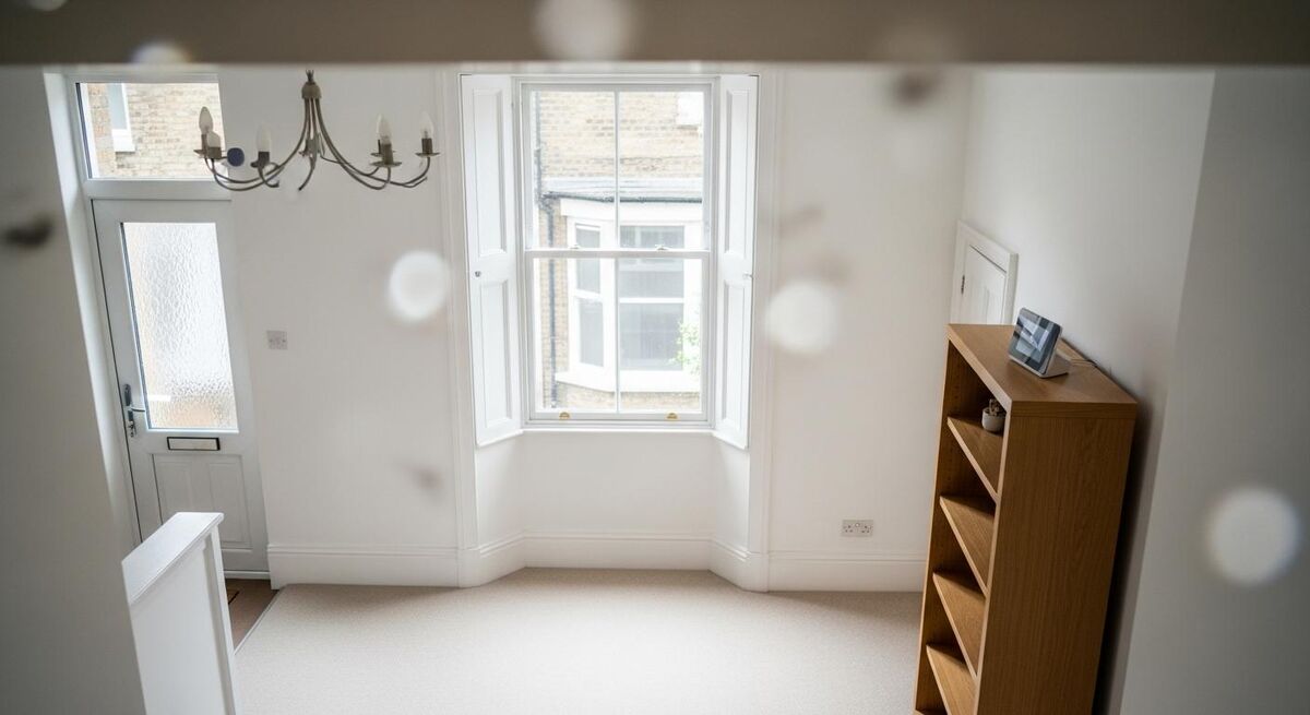 UK terraced house with smart hub on shelf and engineer reviewing tablet